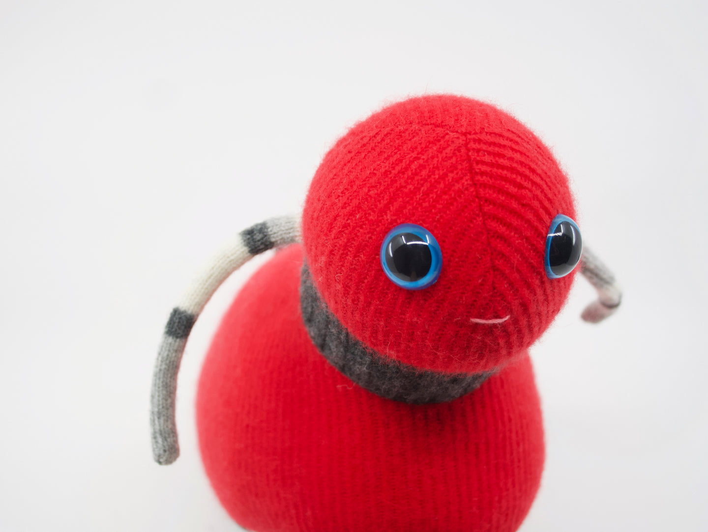 adorable red stuffed animal with blue eyes
