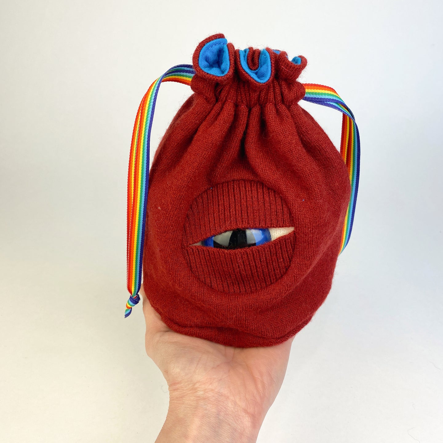 red fabric with blue eye cyclops drawstring bag